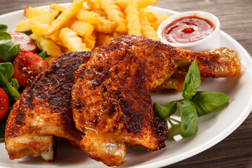 Grilled chicken legs with chips and vegetables