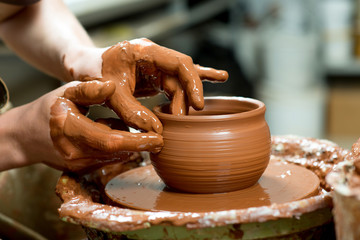 hands of a potter, creating an earthen jar