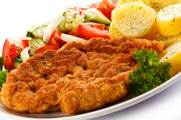 Fried pork chop, boiled potatoes and vegetable salad