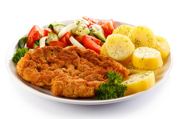 Fried pork chop, boiled potatoes and vegetable salad