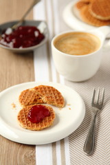 Mini stroopwafels (syrupwaffles) with jam and cup of coffee