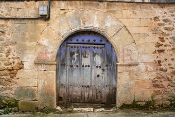 Fototapeta na wymiar puerta azul de madera en casa tipica de piedra