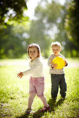boy and girl playing with yellow ball