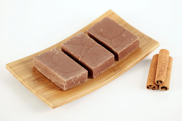 Delicious chocolate with cinnamon sticks on plate