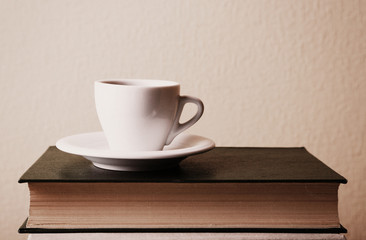 Old books and cup of coffee on table