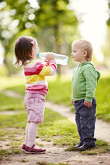 boy and girl drinking mineral water in park