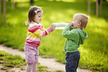 Girl helps boy to keep bottle