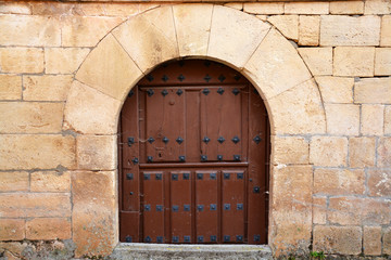 Fototapeta na wymiar puerta de madera antigua en casa tipica de piedra