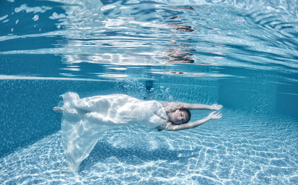 Beautiful woman underwater swiming