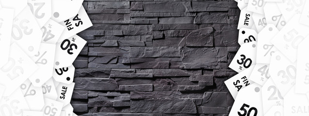 Discount tags on texture of gray stone wall