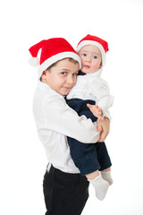 Boys brothers in santa's hats hugging