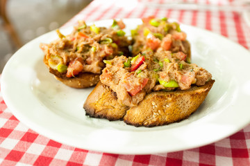 Fototapeta premium three bruschettas with tuna lying on plate at restaurant
