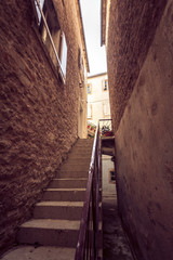 Toned photo of big stairway at narrow street
