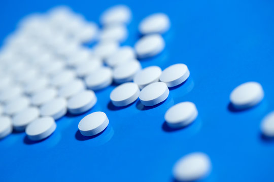 pills. White medical pills on blue background