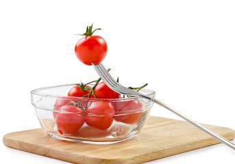 Cherry tomatoes in a glass bowl and fork  with clipping path