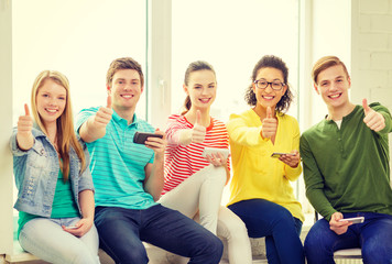 smiling students with smartphone texting at school