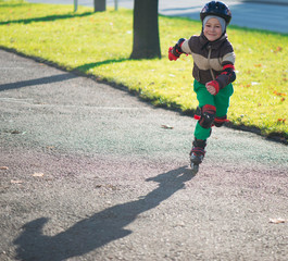 Happy little boy in sunny day on rolle