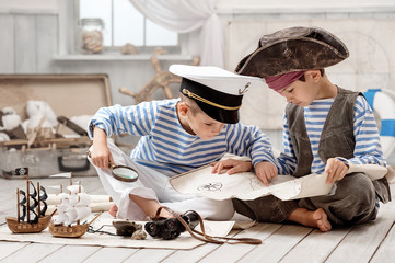 Boys dressed as a pirate captain and read travel map - Powered by Adobe