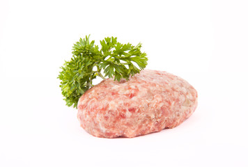 raw meat cutlet with a sprig of parsley on a white background