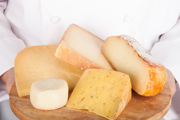 different varieties of cheese on a board in the hands from the c