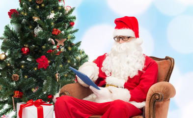 man in costume of santa claus with tablet pc