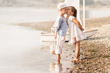 Boy with girl walking along the shore of the lake