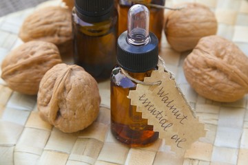 Bottle of walnut essential oil on the woven surface.
