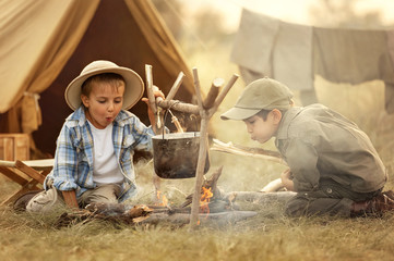 Two of children sitting around the campfire travelers