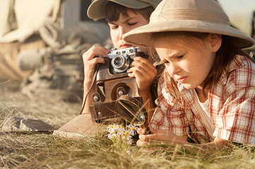 Two children explore insects and plants on earth