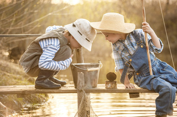 Junge fischt auf einer Brücke am See