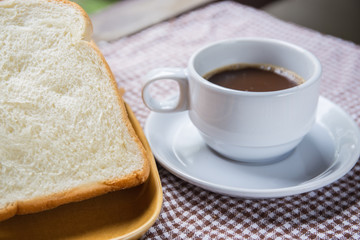 Fototapeta na wymiar cup of coffee bread on table