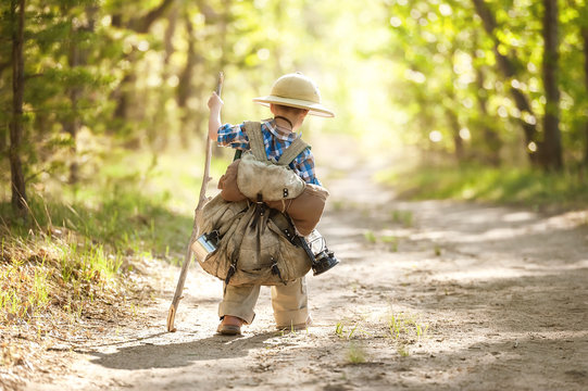 Boy on a forest road with backpacks