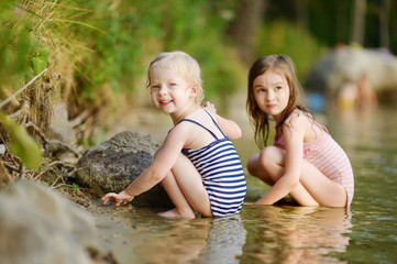 Two little sisters having fun in a river © MNStudio