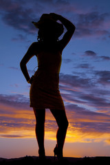 silhouette of cowgirl with hand on hat and hip
