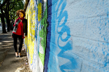 Junge Frau vor Graffitiwand