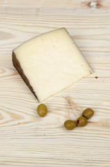 cheese on a wooden rustic table with olives