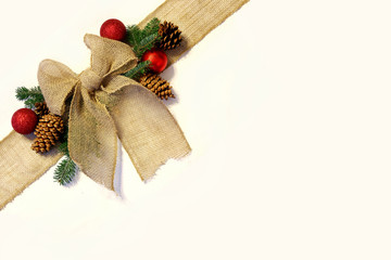 Burlap Christmas Bow, and Ornaments with Pinecones Isolated on W