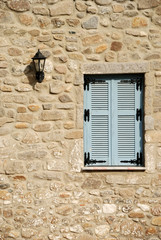 Fototapeta na wymiar Wooden window on stone wall