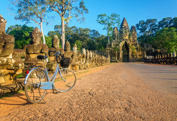 Classic bicycle on road and North Gate of Angkor Wat, Cambodia