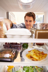 Man Looking Inside Fridge Filled With Food