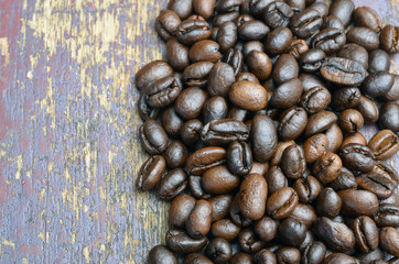 Roasted coffee beans on textured wood.