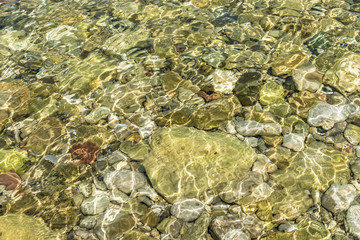 Clean clear sea water and pebbles on the beach