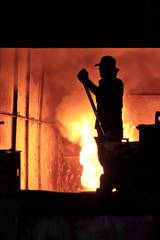 Man is working in the splashing molten iron - Stock Image
