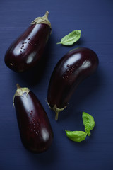 Above view of fresh aubergines on a dark blue wooden surface
