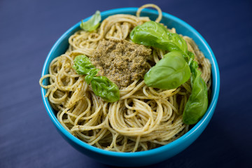 Glass bowl with spaghetti served with basil pesto sauce