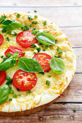 Pizza with cheese tomatoes and greens