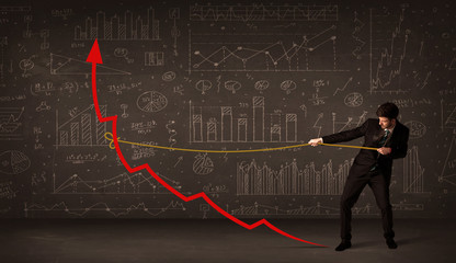 Businessman pulling a red arrow upright with a rope