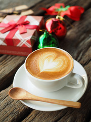 Coffee latte art and the X-mas present box on the wood backgroun
