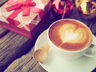 Coffee latte art and the X-mas present box on the wood backgroun