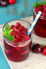 Closeup of cherry granita in glasses, on color wooden